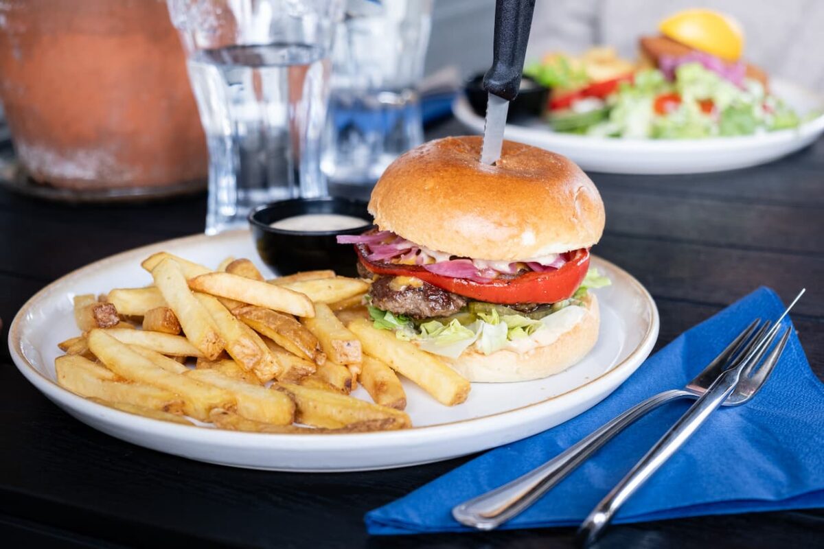 Beef burger with lettuce, tomato, onion and pickles served with fries and a dipping sauce.